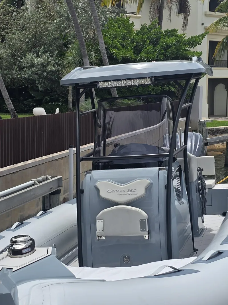 Slide: The Image of 2025 Ranieri CAYMAN 26 SPORT TOURING boat docked near tropical foliage. - 30