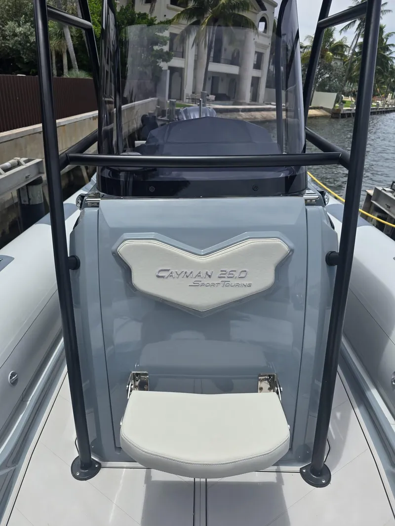 Slide: The Image of 2025 Ranieri Cayman 26 Sport Touring boat, sleek design, docked by waterfront. - 32