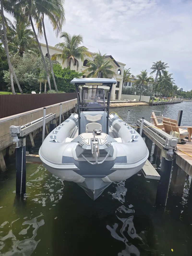 Slide: The Image of 2025 Ranieri CAYMAN 26 SPORT TOURING docked by palm trees and waterfront homes. - 36