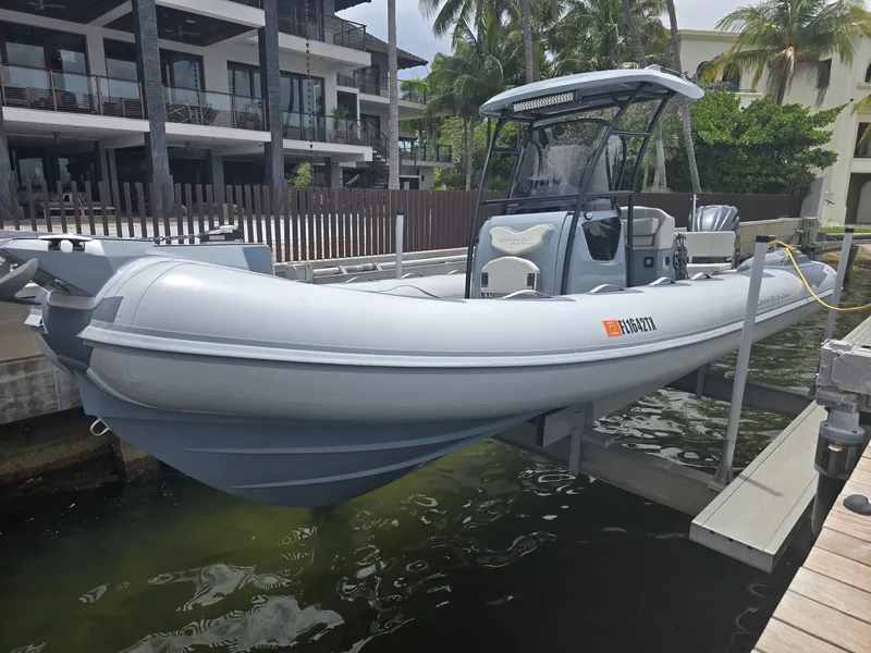 Slide: The Image of 2025 Ranieri CAYMAN 26 SPORT TOURING boat docked near modern waterfront property. - 37