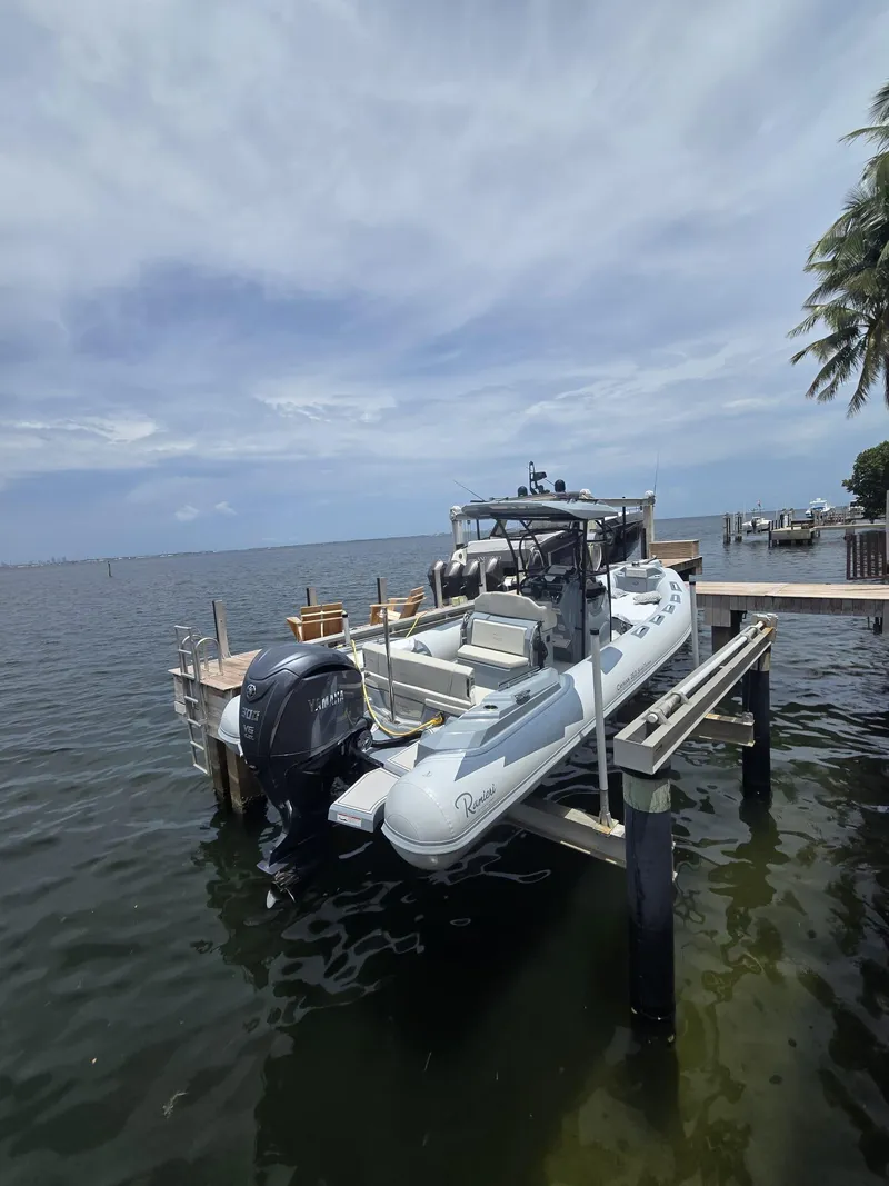 Slide: The Image of 2025 Ranieri CAYMAN 26 SPORT TOURING boat docked by the waterfront under a cloudy sky. - 4