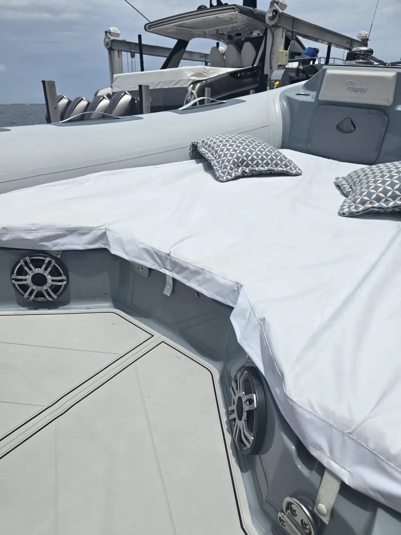 Slide: The Image of 2025 Ranieri CAYMAN 26 SPORT TOURING boat with cushioned seating and patterned pillows. - 40