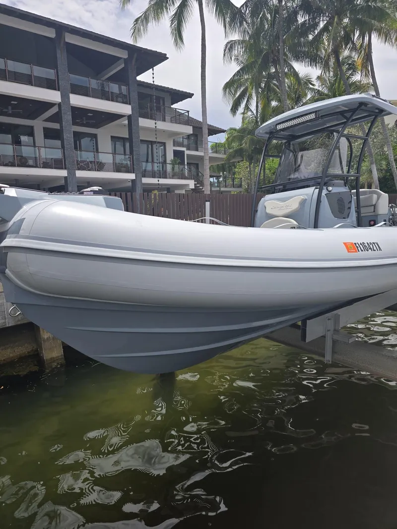 Slide: The Image of 2025 Ranieri CAYMAN 26 SPORT TOURING boat docked near modern building and palm trees. - 42