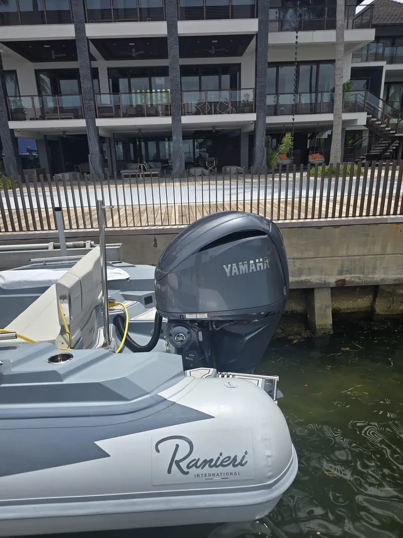 Slide: The Image of 2025 Ranieri CAYMAN 26 SPORT TOURING boat with Yamaha engine docked near modern building. - 8