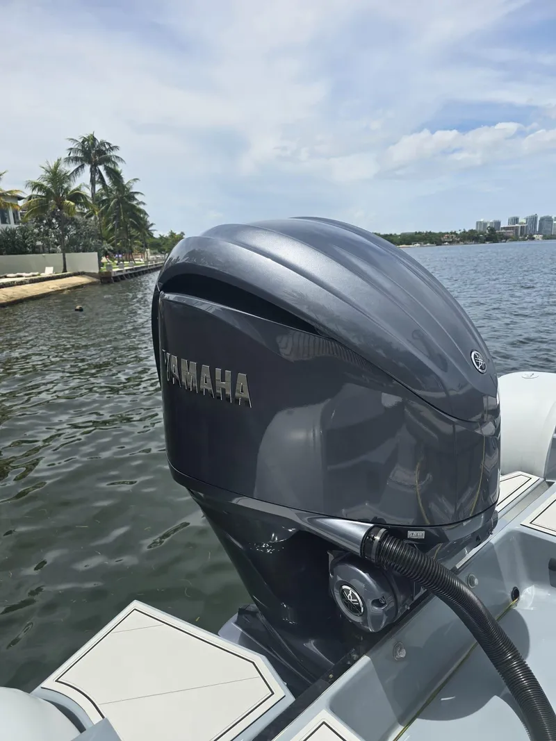 Slide: The Image of Yamaha outboard motor on 2025 Ranieri CAYMAN 26 SPORT TOURING boat, near tropical shoreline. - 9