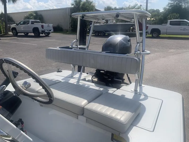 Slide: The Image of 2018 Custom Biscayne boat interior with white seating and steering wheel in a parking lot. - 10