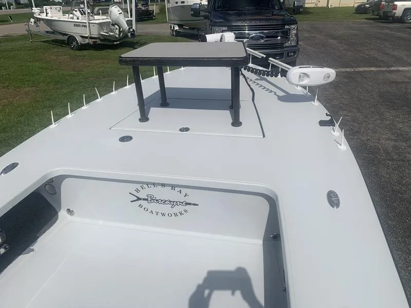 Slide: The Image of 2018 Custom Biscayne boat with elevated platform, parked near a truck and other boats. - 16