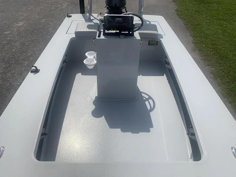 Slide: The Image of 2018 Custom Biscayne boat interior with steering console and cup holders, parked on grass. - 18