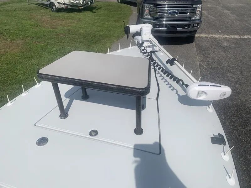 Slide: The Image of Custom 2018 Biscayne boat deck with table and trolling motor, parked near a Ford truck. - 19