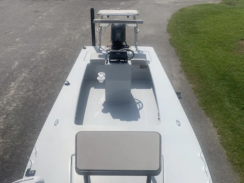 Slide: The Image of 2018 Custom Biscayne boat with outboard motor, parked on pavement near grass. - 22