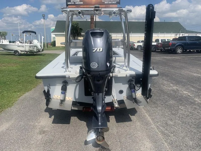 Slide: The Image of Custom Biscayne 2018 boat with 70 HP outboard motor, parked outdoors on a sunny day. - 3