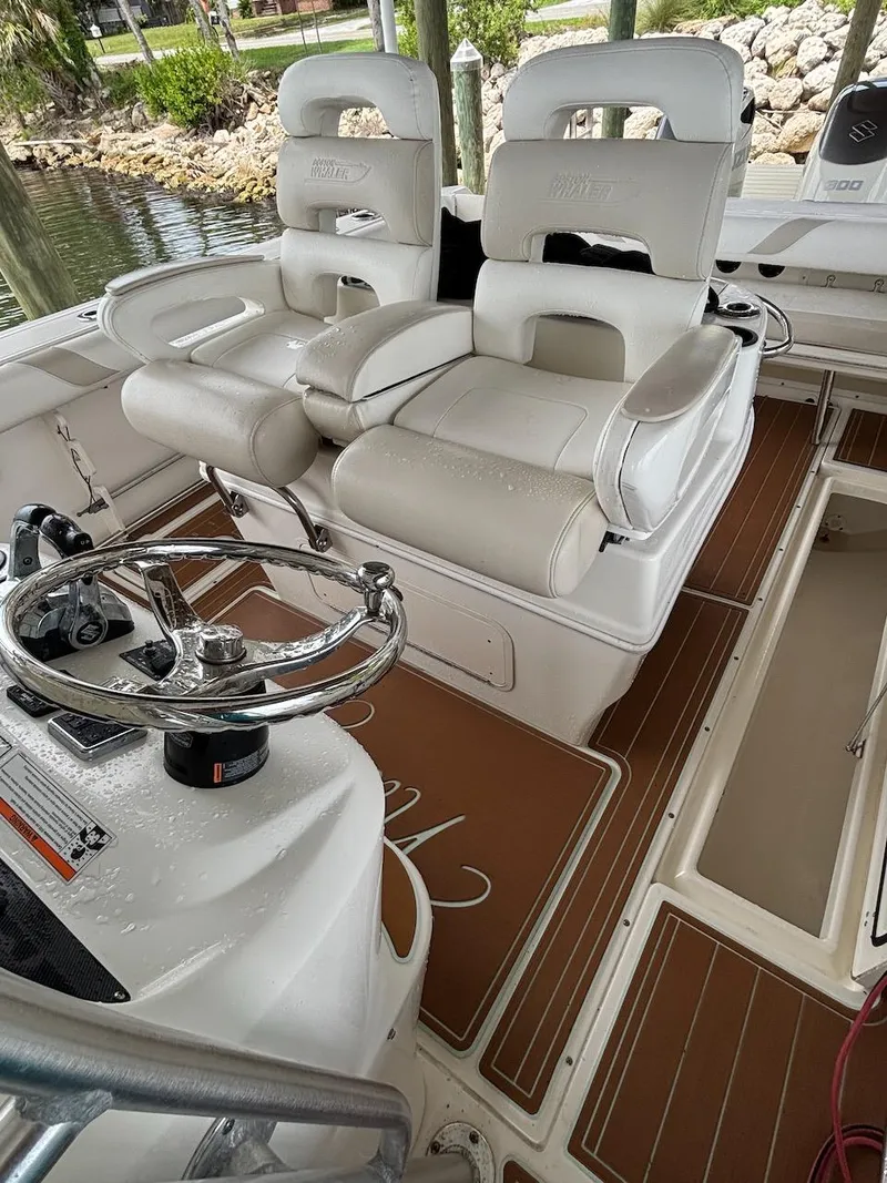 Slide: The Image of Interior of a 2006 Boston Whaler 320 Outrage boat with white seating and steering wheel. - 16