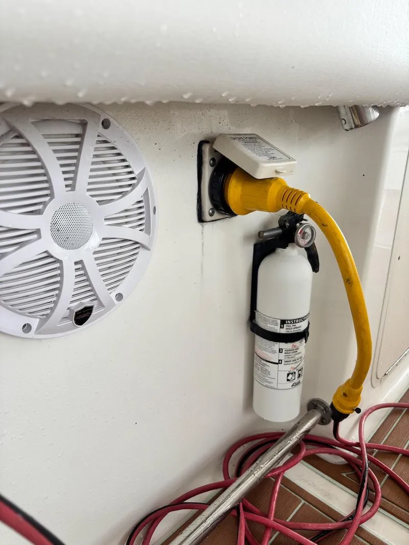 Slide: The Image of 2006 Boston Whaler 320 Outrage boat interior with speaker, power connection, and fire extinguisher. - 27