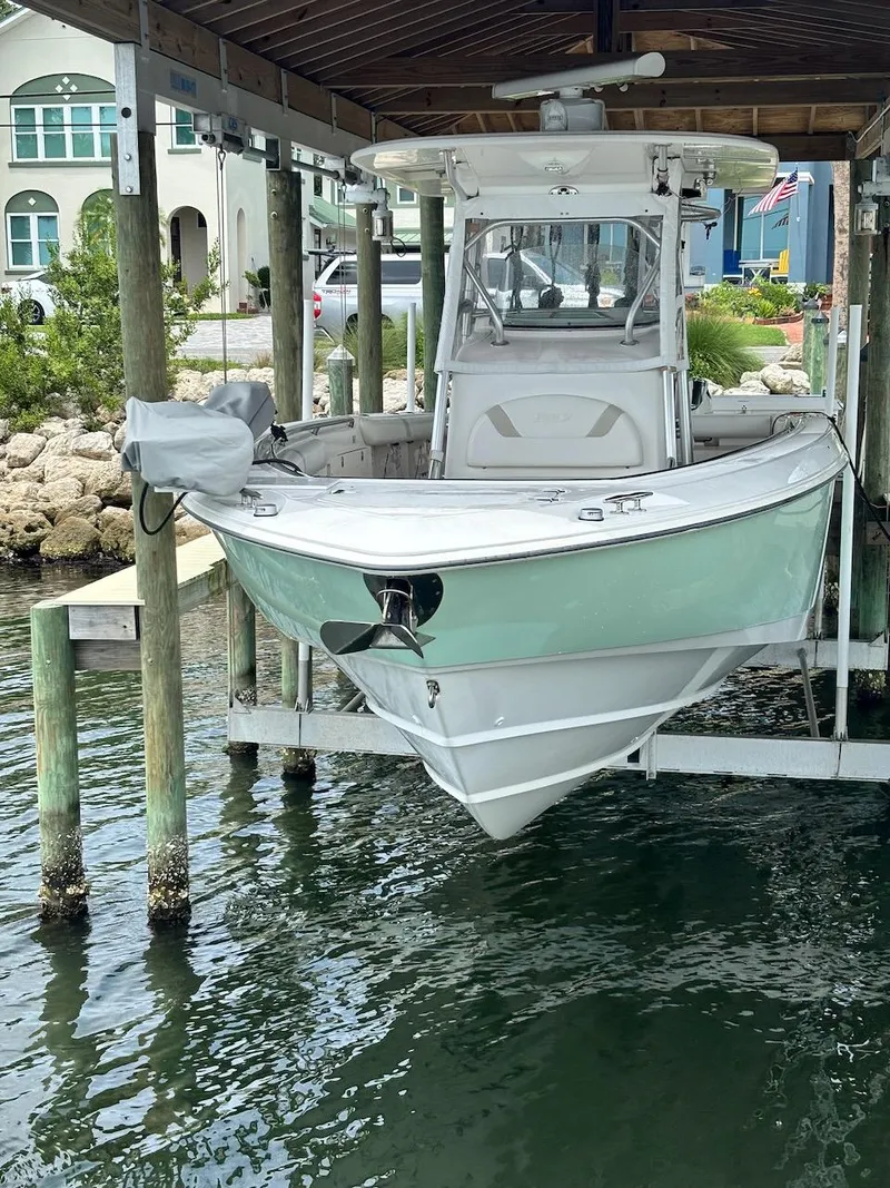Slide: The Image of 2006 Boston Whaler 320 Outrage boat docked under a wooden shelter. - 31