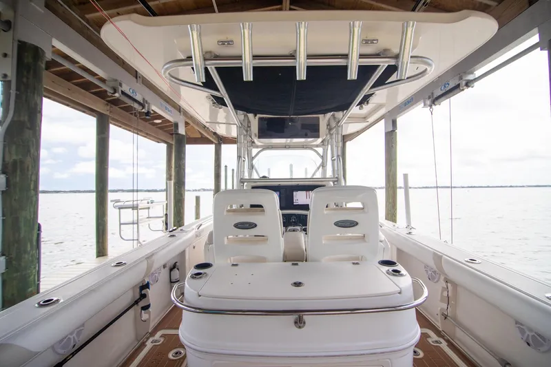 Slide: The Image of 2006 Boston Whaler 320 Outrage boat interior with helm and seating, docked by the water. - 36