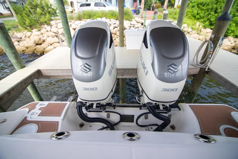 Slide: The Image of Twin Suzuki 300 outboard engines on a 2006 Boston Whaler 320 Outrage boat at dock. - 45