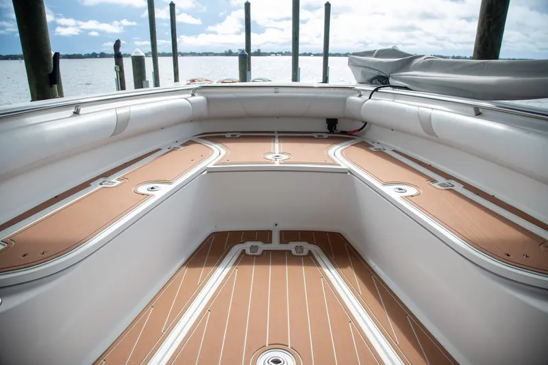Slide: The Image of 2006 Boston Whaler 320 Outrage boat interior with teak flooring, docked by the water. - 49