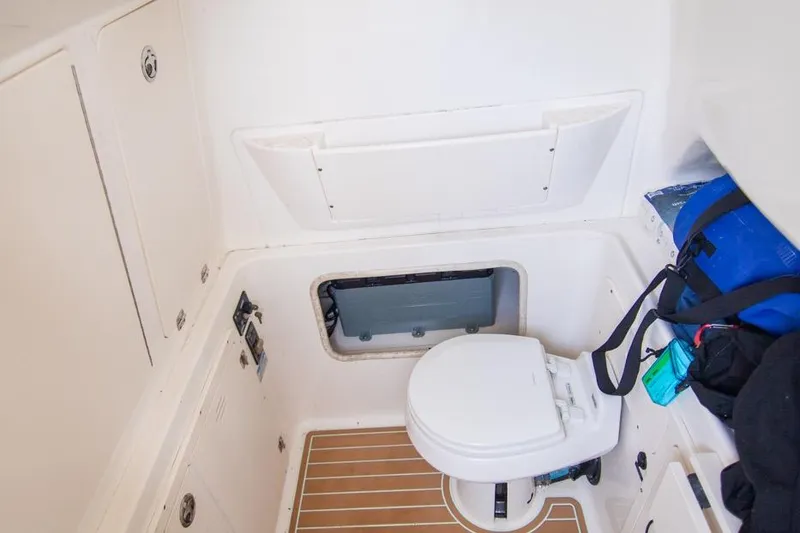 Slide: The Image of 2006 Boston Whaler 320 Outrage boat interior with toilet and storage area. - 50