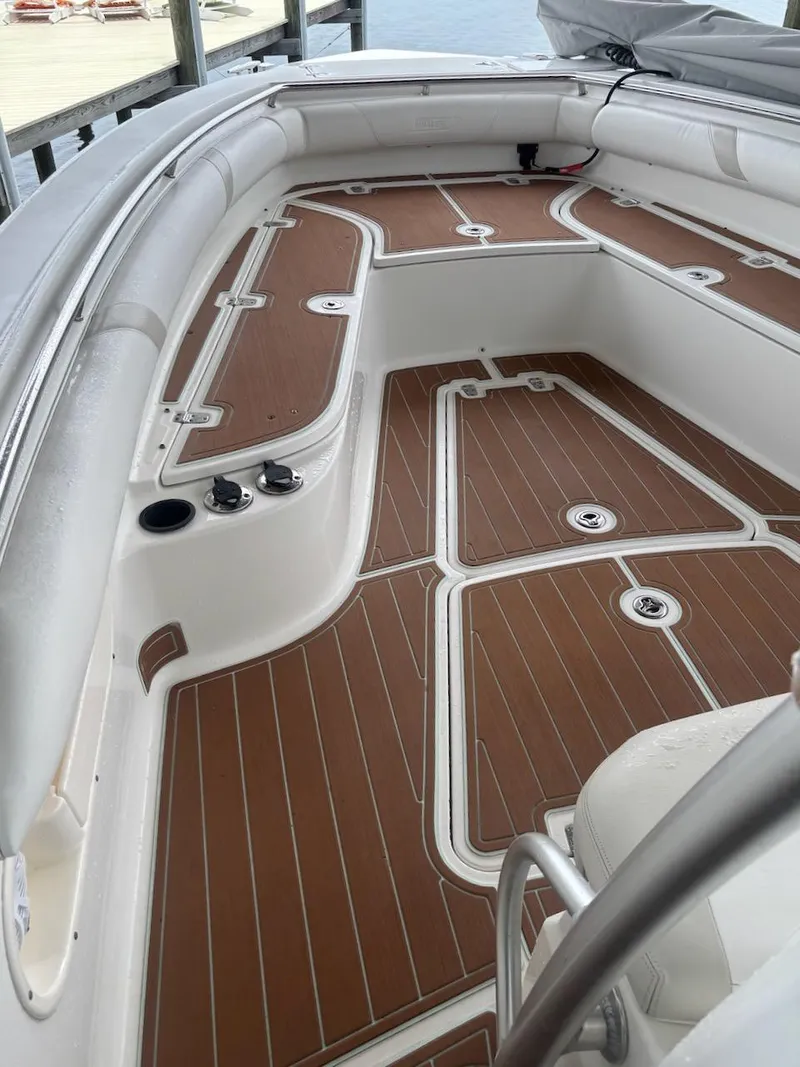 Slide: The Image of 2006 Boston Whaler 320 Outrage boat interior with teak-style flooring and cushioned seating. - 9
