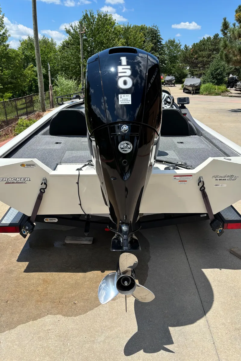 Slide: The Image of 2020 Tracker Pro Team 195 TXW Tournament Edition boat with 150 HP engine, parked outdoors. - 2