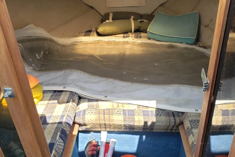 Slide: The Image of 1984 Rinker V205 Cuddy Cabin interior with cushions and storage space. - 10