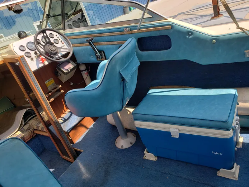 Slide: The Image of 1984 Rinker V205 Cuddy Cabin interior with blue seating and steering wheel. - 12