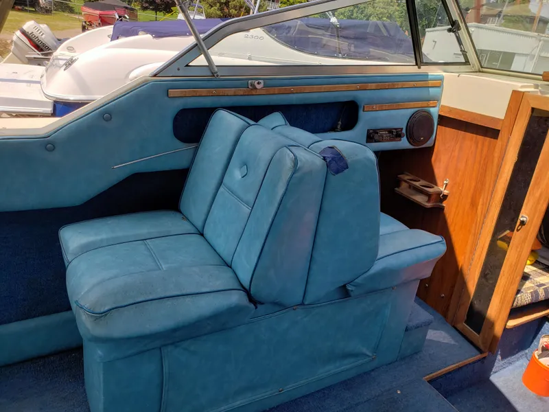 Slide: The Image of 1984 Rinker V205 Cuddy Cabin interior with blue seating and wooden accents. - 13