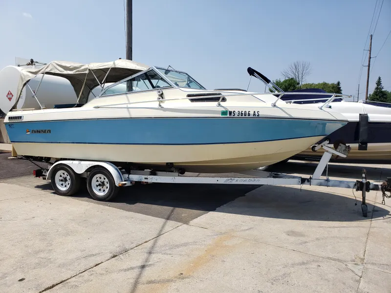 Slide: The Image of 1984 Rinker V205 Cuddy Cabin boat on trailer, blue and white exterior, parked outdoors. - 2