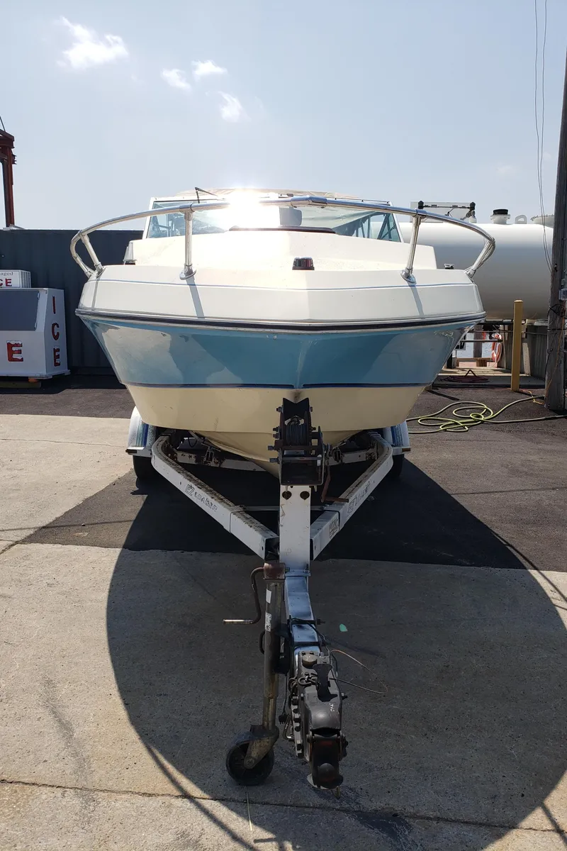 Slide: The Image of 1984 Rinker V205 Cuddy Cabin boat on trailer, parked outdoors under sunny sky. - 3