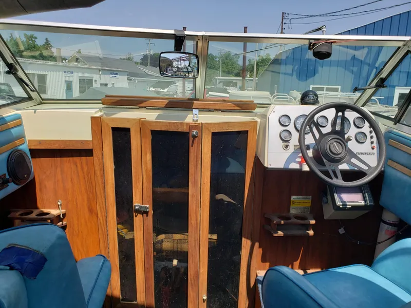 Slide: The Image of 1984 Rinker V205 Cuddy Cabin interior with steering wheel, gauges, and wooden cabinetry. - 8