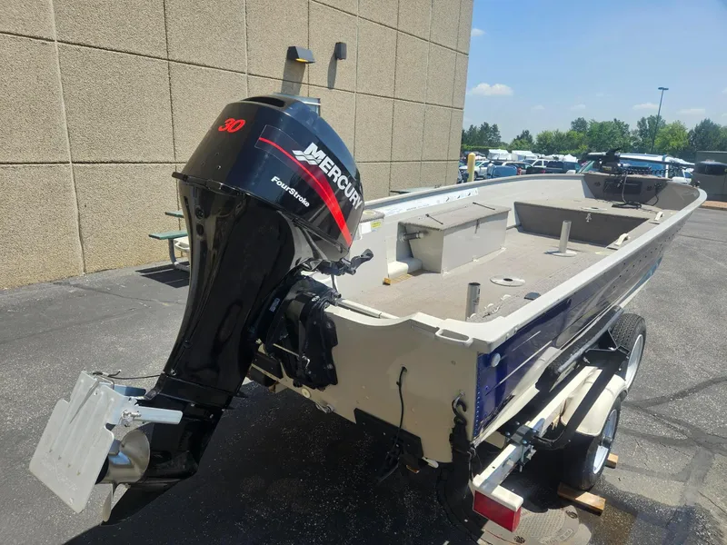 Slide: The Image of 2003 Sylvan 16SPTLTL boat with Mercury 30 FourStroke engine on trailer, parked outdoors. - 4
