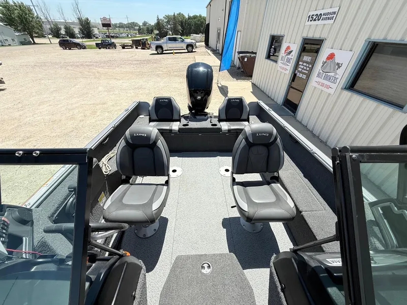 Slide: The Image of 2020 Lund 1775 Impact boat interior with seating, parked outside a building. - 20