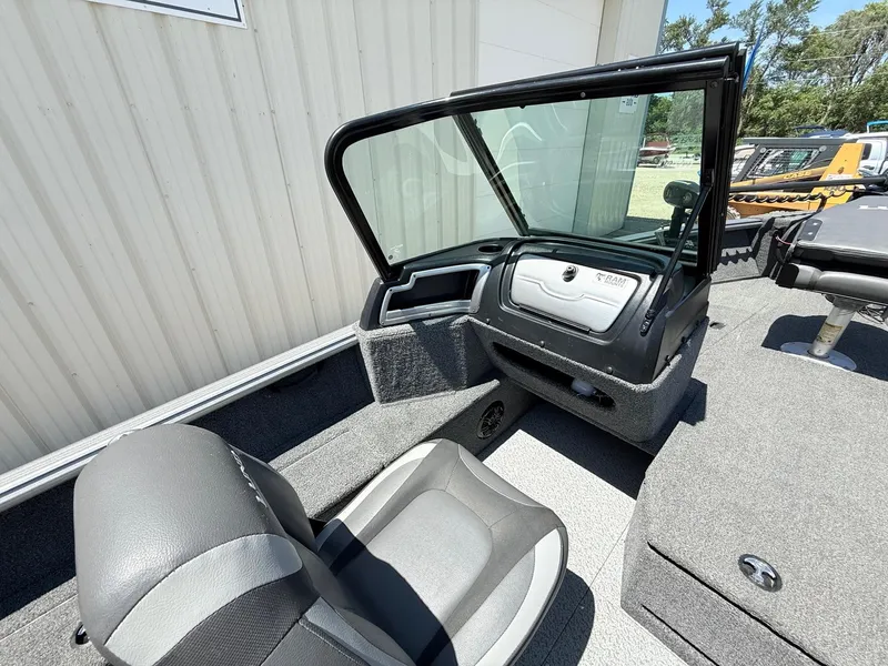 Slide: The Image of 2020 Lund 1775 Impact boat interior with seating and console, parked outdoors. - 22