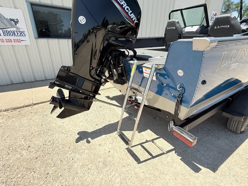 Slide: The Image of 2020 Lund 1775 Impact boat with Mercury engine and ladder, parked outside a building. - 27