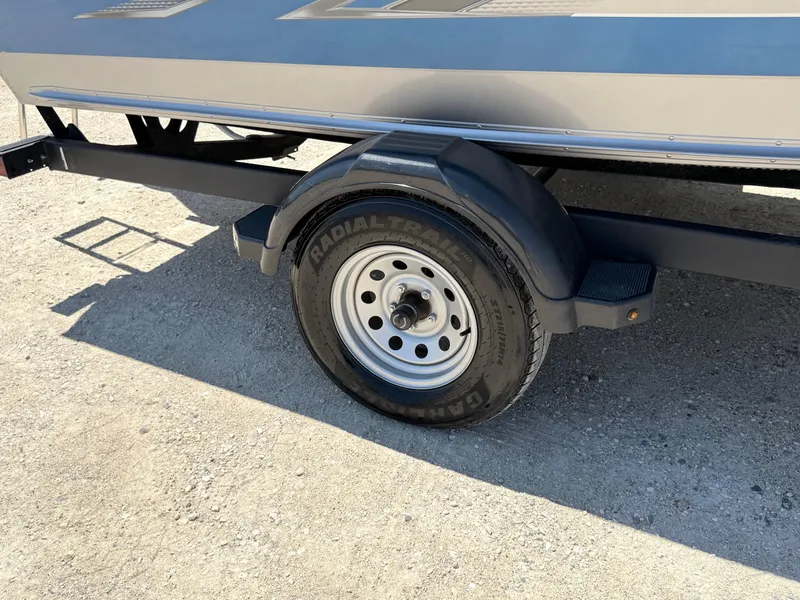 Slide: The Image of 2020 Lund 1775 Impact boat trailer wheel on gravel surface. - 28
