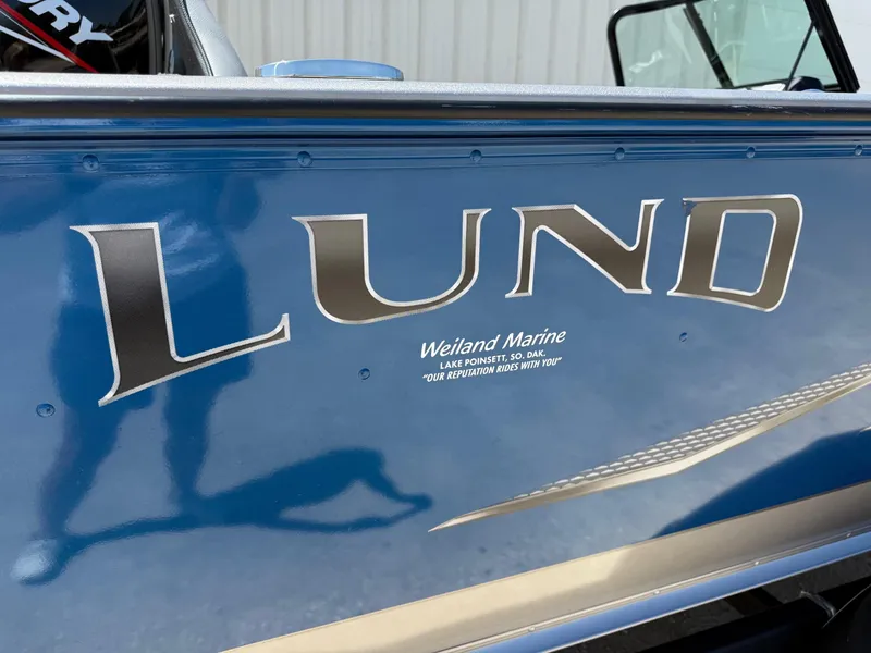 Slide: The Image of 2020 Lund 1775 Impact boat side view with logo and dealership details. - 5