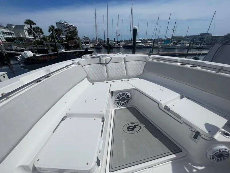 Slide: The Image of 2022 Sea Fox 368 Commander boat interior with seating and speakers in a marina setting. - 14