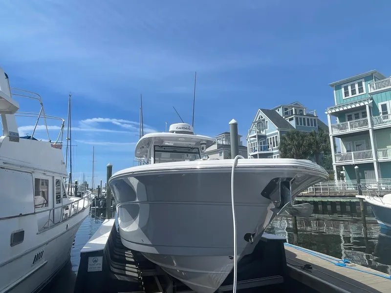 Slide: The Image of 2022 Sea Fox 368 Commander docked at marina with coastal homes in background. - 2