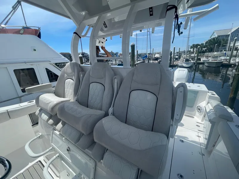 Slide: The Image of 2022 Sea Fox 368 Commander boat interior with plush seating at a marina. - 28