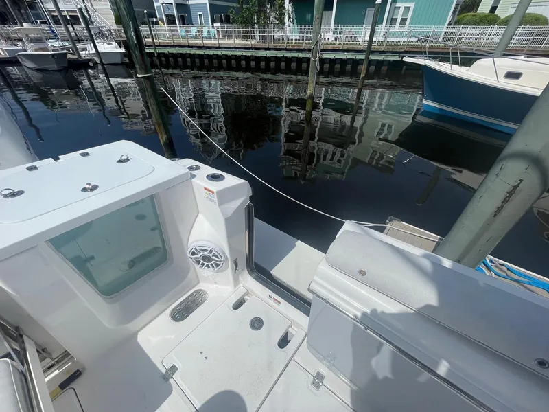 Slide: The Image of 2022 Sea Fox 368 Commander boat docked, showcasing deck and water reflection. - 29