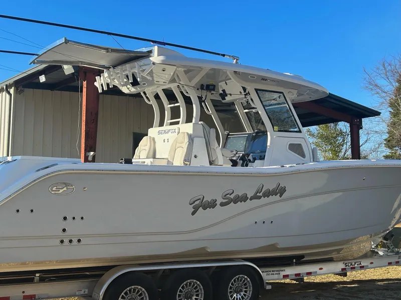Slide: The Image of 2022 Sea Fox 368 Commander boat on trailer, parked outdoors under clear blue sky. - 3