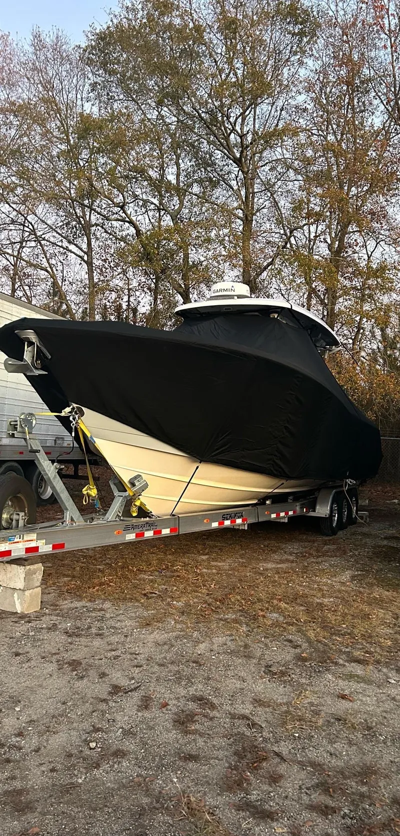 Slide: The Image of 2022 Sea Fox 368 Commander boat covered on trailer, surrounded by trees. - 5