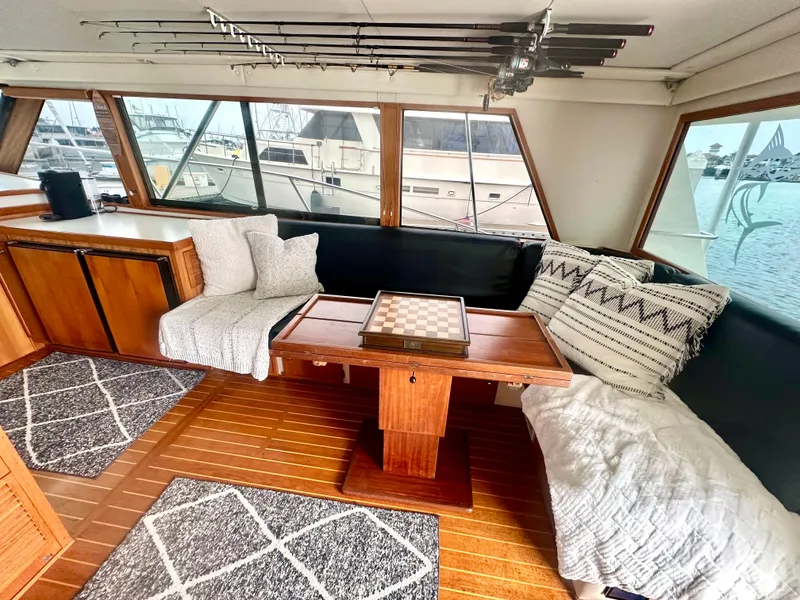 Slide: The Image of 1975 Hatteras Sport Fisher interior with chess table, cozy seating, and fishing rods. - 12