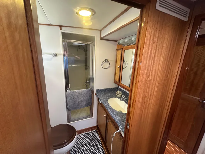 Slide: The Image of 1975 Hatteras Sport Fisher bathroom with wood accents, shower, and vanity. - 16