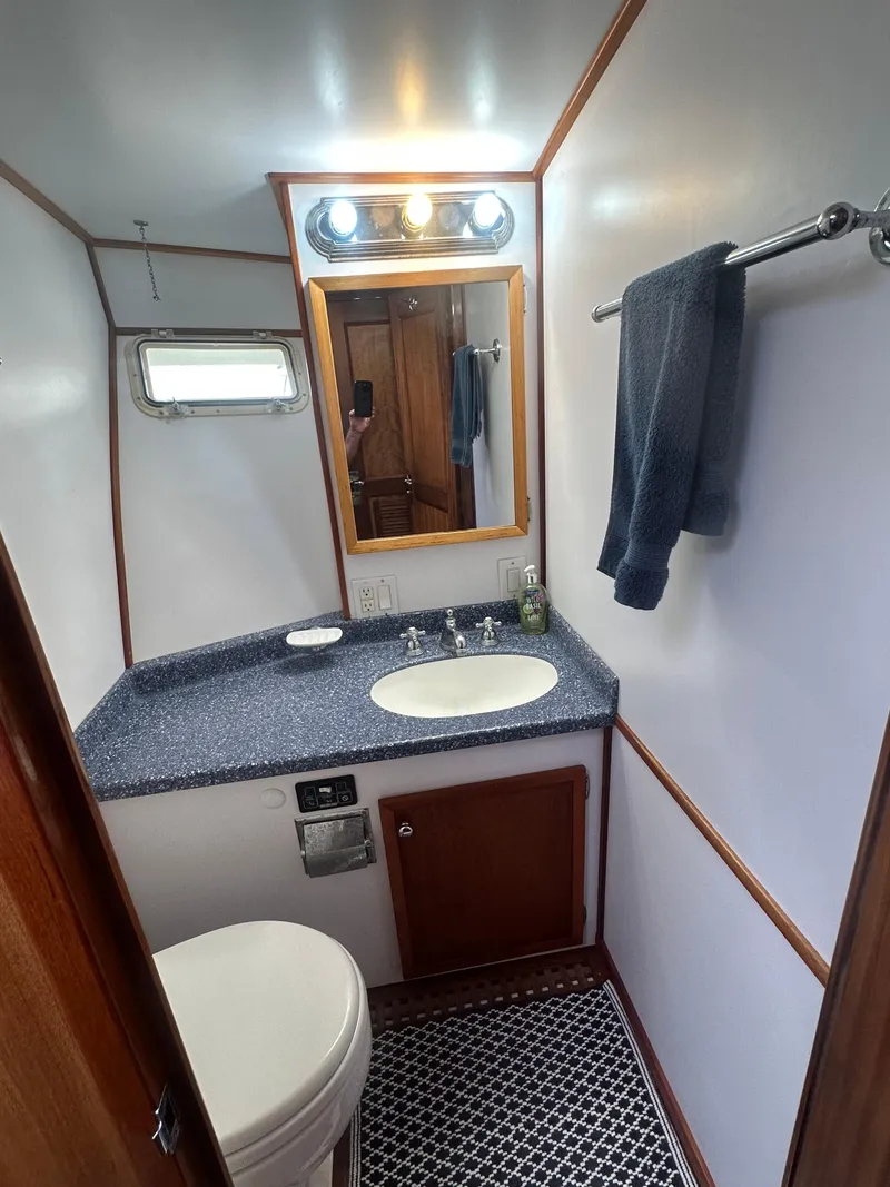 Slide: The Image of 1975 Hatteras Sport Fisher bathroom with modern fixtures, blue countertop, and patterned floor. - 21