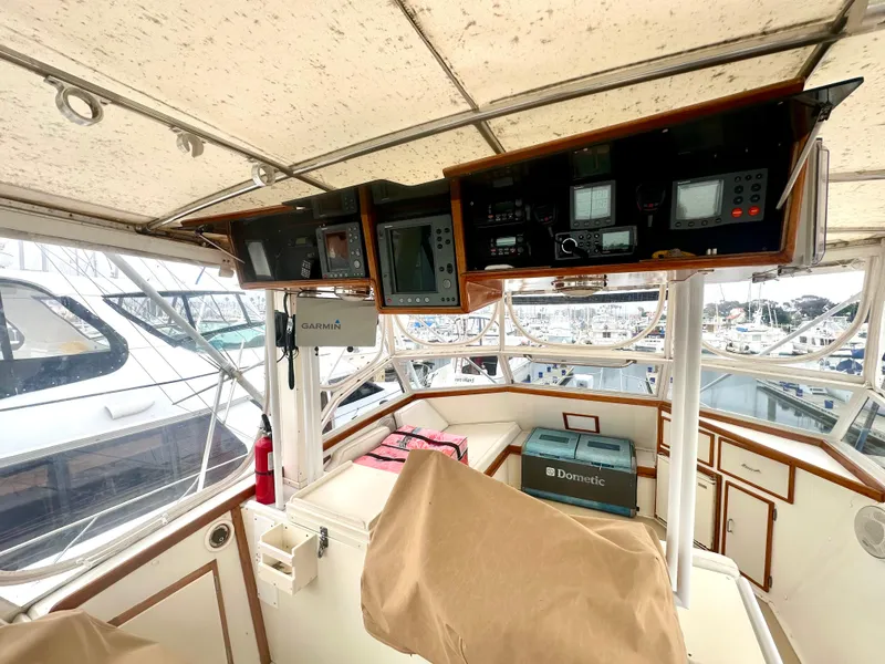 Slide: The Image of 1975 Hatteras Sport Fisher helm with navigation equipment and marina view. - 24