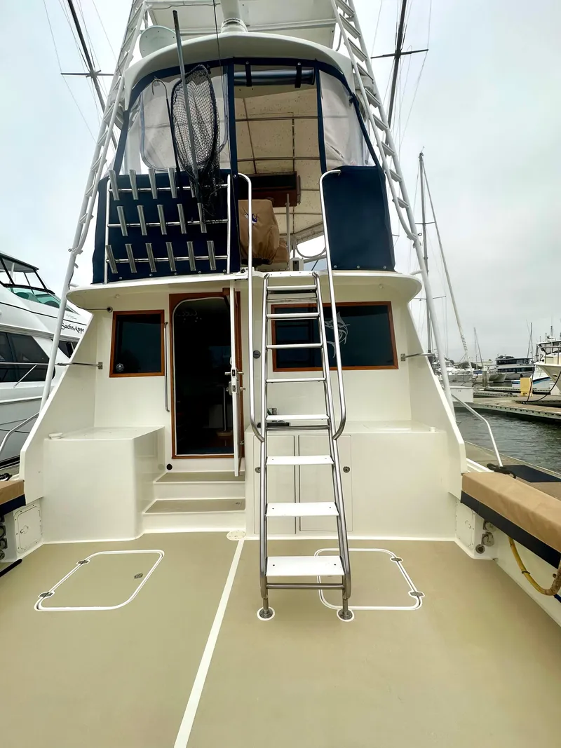 Slide: The Image of 1975 Hatteras Sport Fisher boat with ladder and fishing gear, docked at marina. - 27