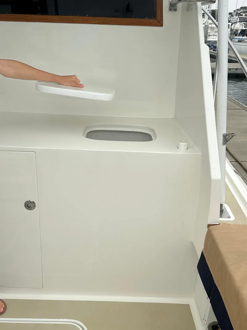 Slide: The Image of 1975 Hatteras Sport Fisher boat interior with a hand lifting a hatch cover. - 30