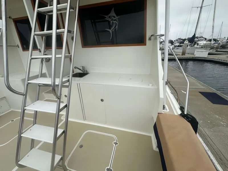 Slide: The Image of 1975 Hatteras Sport Fisher boat interior with ladder and sink, docked at marina. - 31