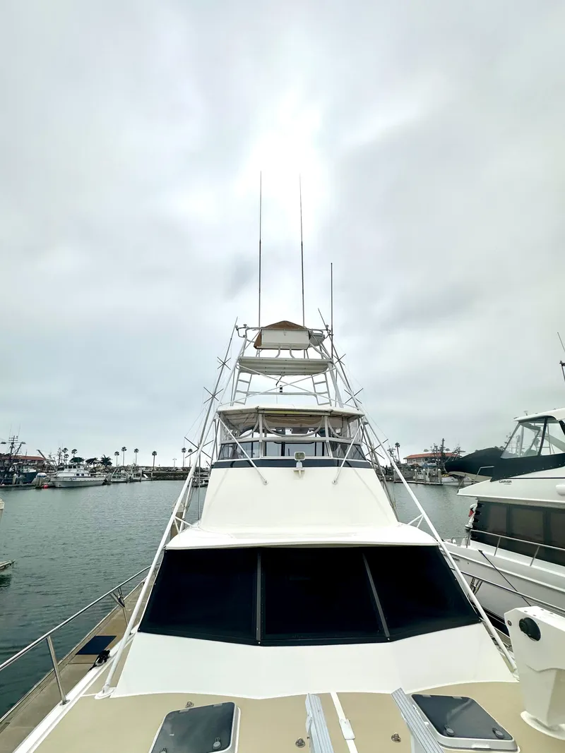 Slide: The Image of 1975 Hatteras Sport Fisher boat docked in a marina under cloudy skies. - 32